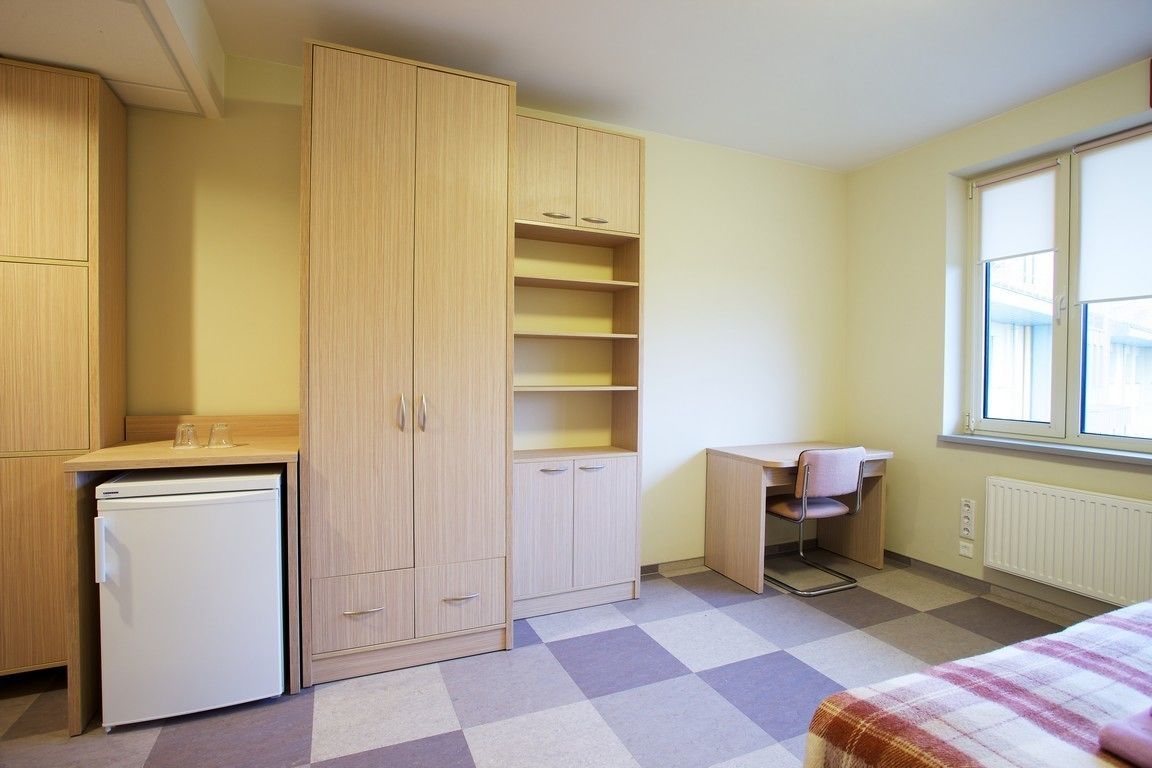 Un dormitorio pequeño con cama, escritorio y armario.