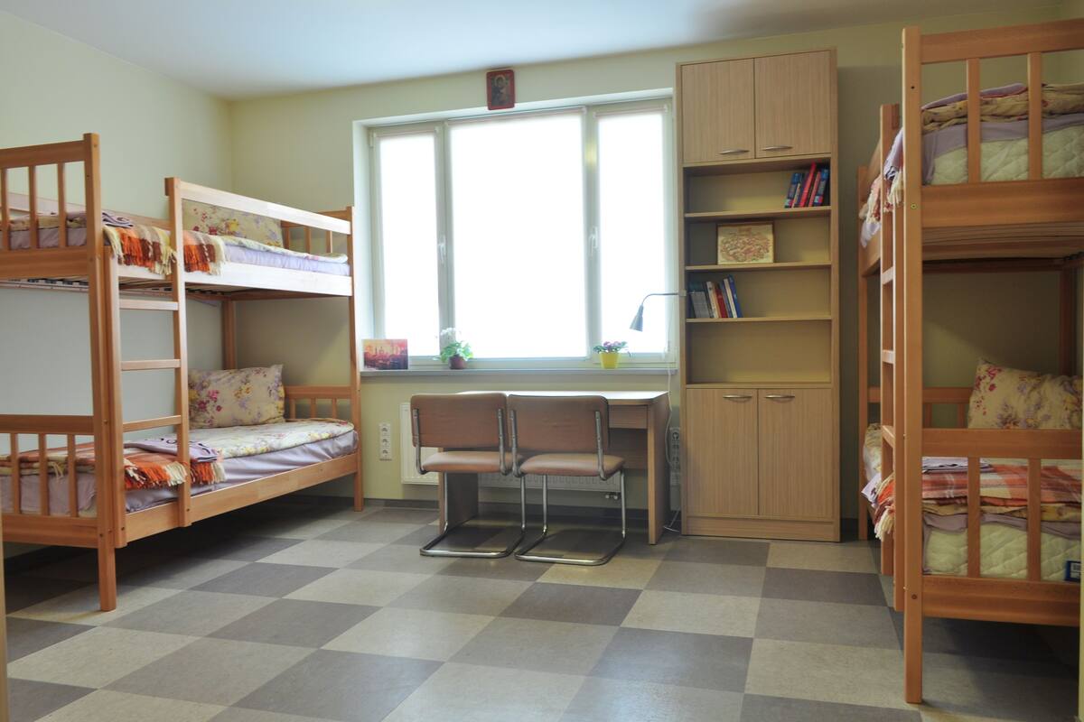 Une chambre avec des lits superposés, un bureau et une chaise.
