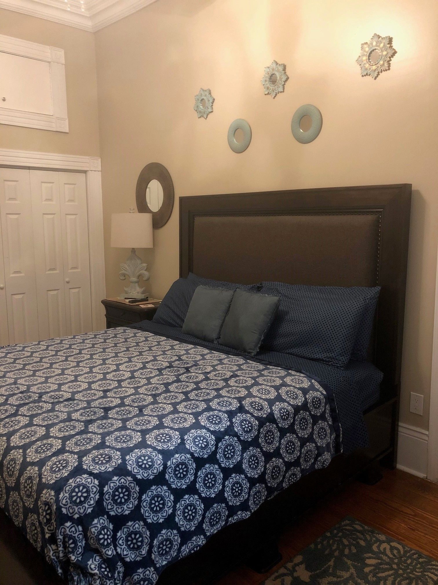 Ein Schlafzimmer mit einem großen Bett, einem Nachttisch, einer Kommode und dekorativen Wandbildern.