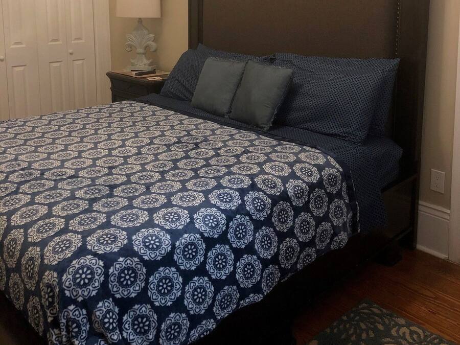 Ein Schlafzimmer mit einem großen Bett, einem Nachttisch, einer Kommode und dekorativen Wandbildern.
