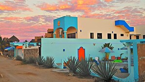 A row of colorful buildings with a sunset sky. - Villa Star of the Sea - Adults Only (Isla Navidad)