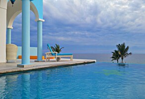 Una piscina al aire libre, sombrillas, sillones reclinables de piscina