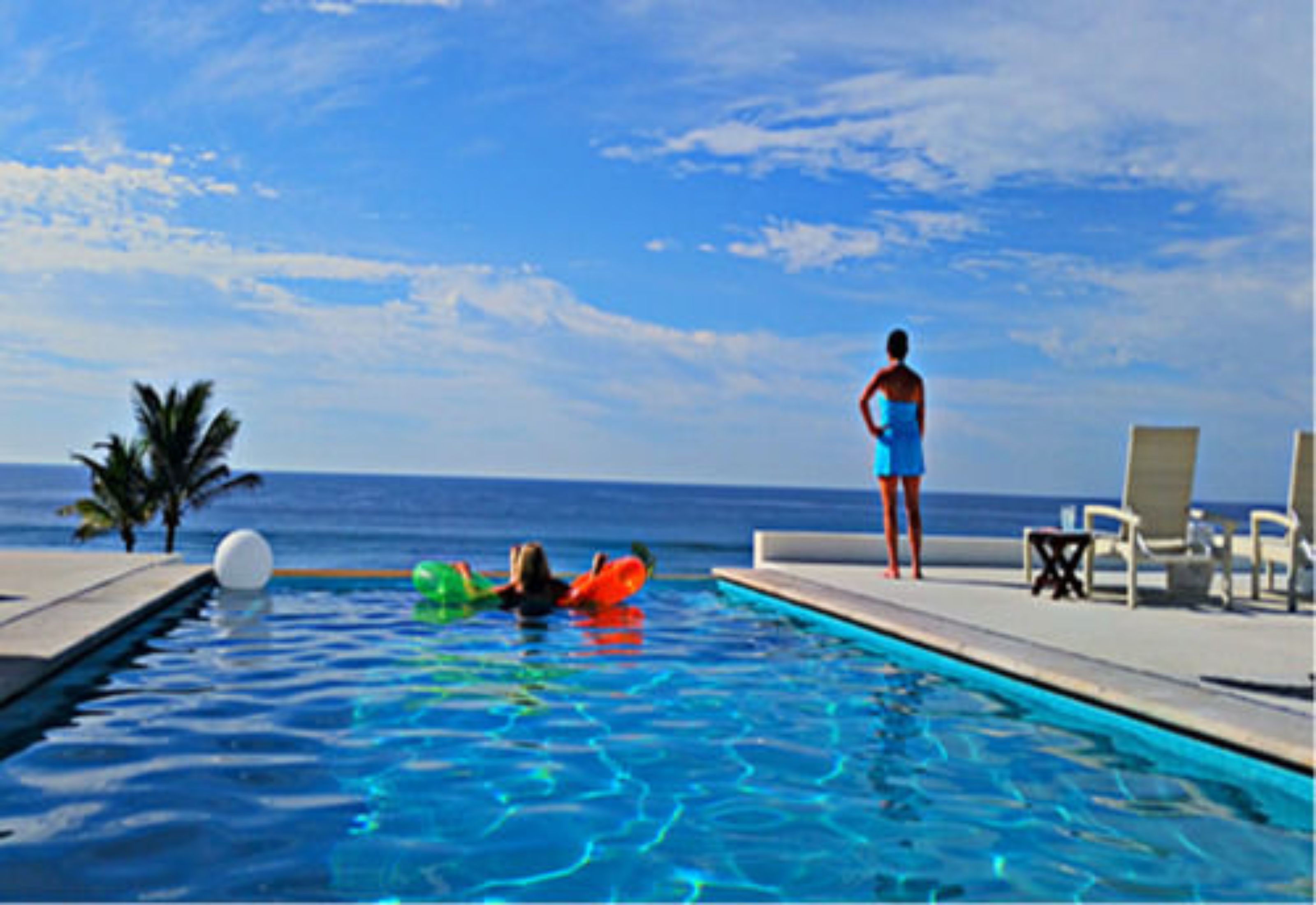 Alberca al aire libre, sombrillas en la alberca y camastros 