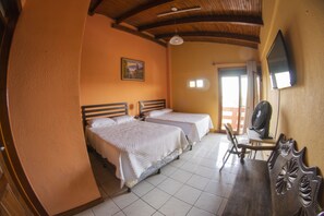 A room with two beds, a desk, a chair, and a TV mounted on the wall. - Euro Hostal - Hostel (Guatemala City)