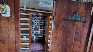 A wooden interior with a wooden table and a patterned rug. - Chinook Cabins & RV Park (South Fork)