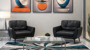 A modern lobby with two leather sofas, a glass coffee table, and abstract artwork on the wall. - Chaparral Motor Inn (Burlington)