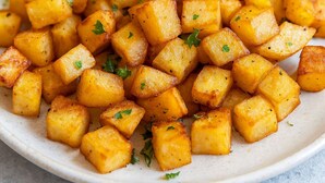 A plate of cubed potatoes garnished with herbs. - Chaparral Motor Inn (Burlington)