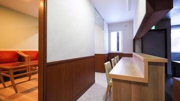 Una habitación con una mesa de comedor de madera, un sofá y un ventanal.