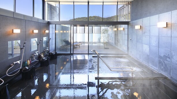 A modern indoor pool area with clear glass walls, multiple faucets, and a clean, reflective floor. - Atami Tensui (Atami)