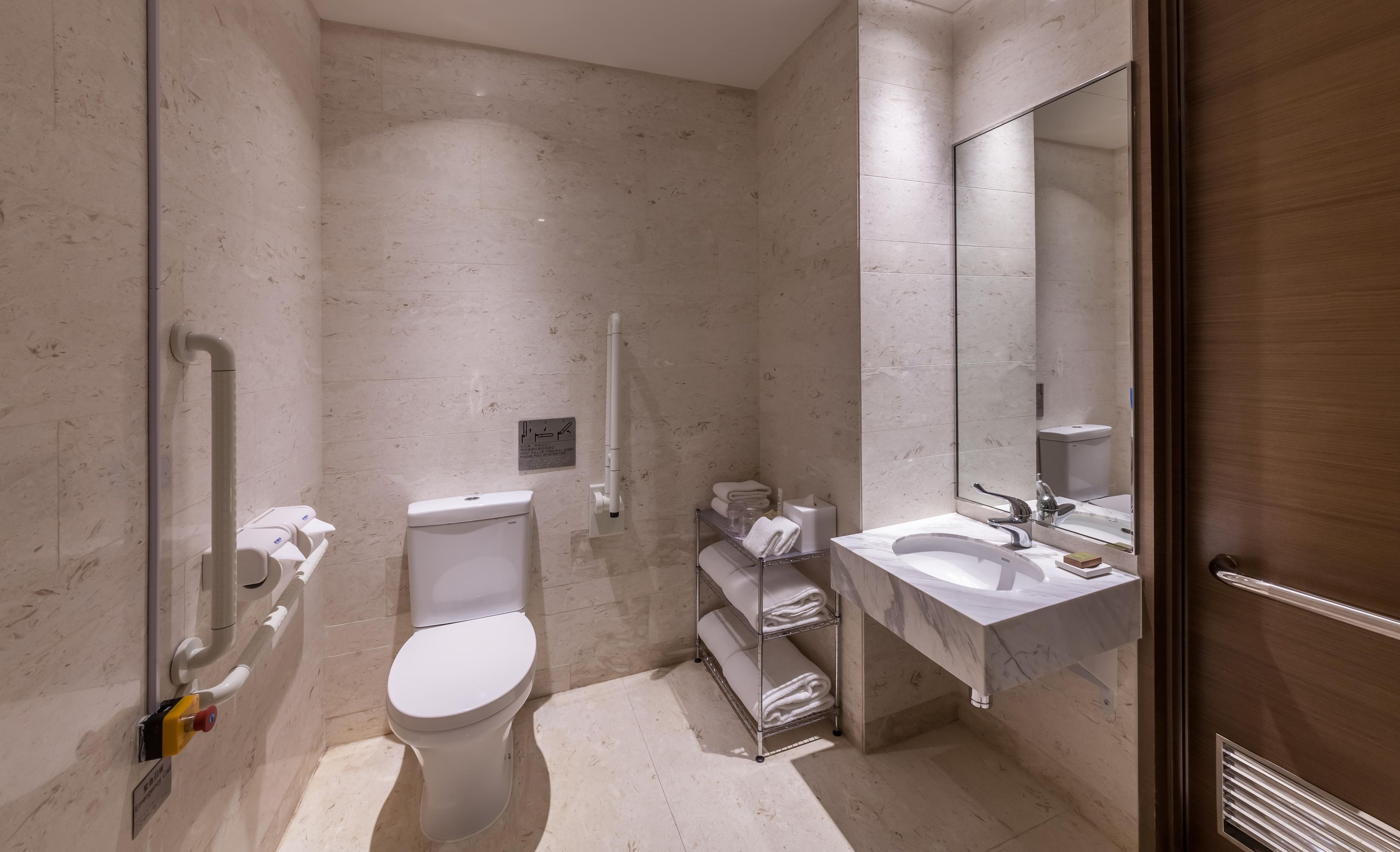 A modern bathroom with a toilet, sink, and shower area.
