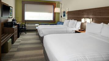 A hotel room with two beds, a desk with a computer, a chair, and a large window.