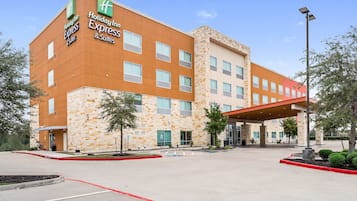 Edificio Holiday Inn Express con fachada de piedra, múltiples ventanas y entrada cubierta.