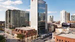 A modern hotel with a glass facade, multiple floors, and a prominent sign. - Hampton Inn Chicago West Loop Fulton Market Area (Chicago)