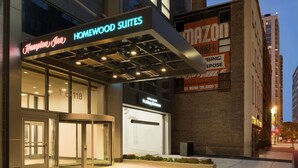A hotel entrance with a neon sign for Hampton Inn and Homewood Suites, a parking entrance, and a brick building with a large sign. - Hampton Inn Chicago West Loop Fulton Market Area (Chicago)