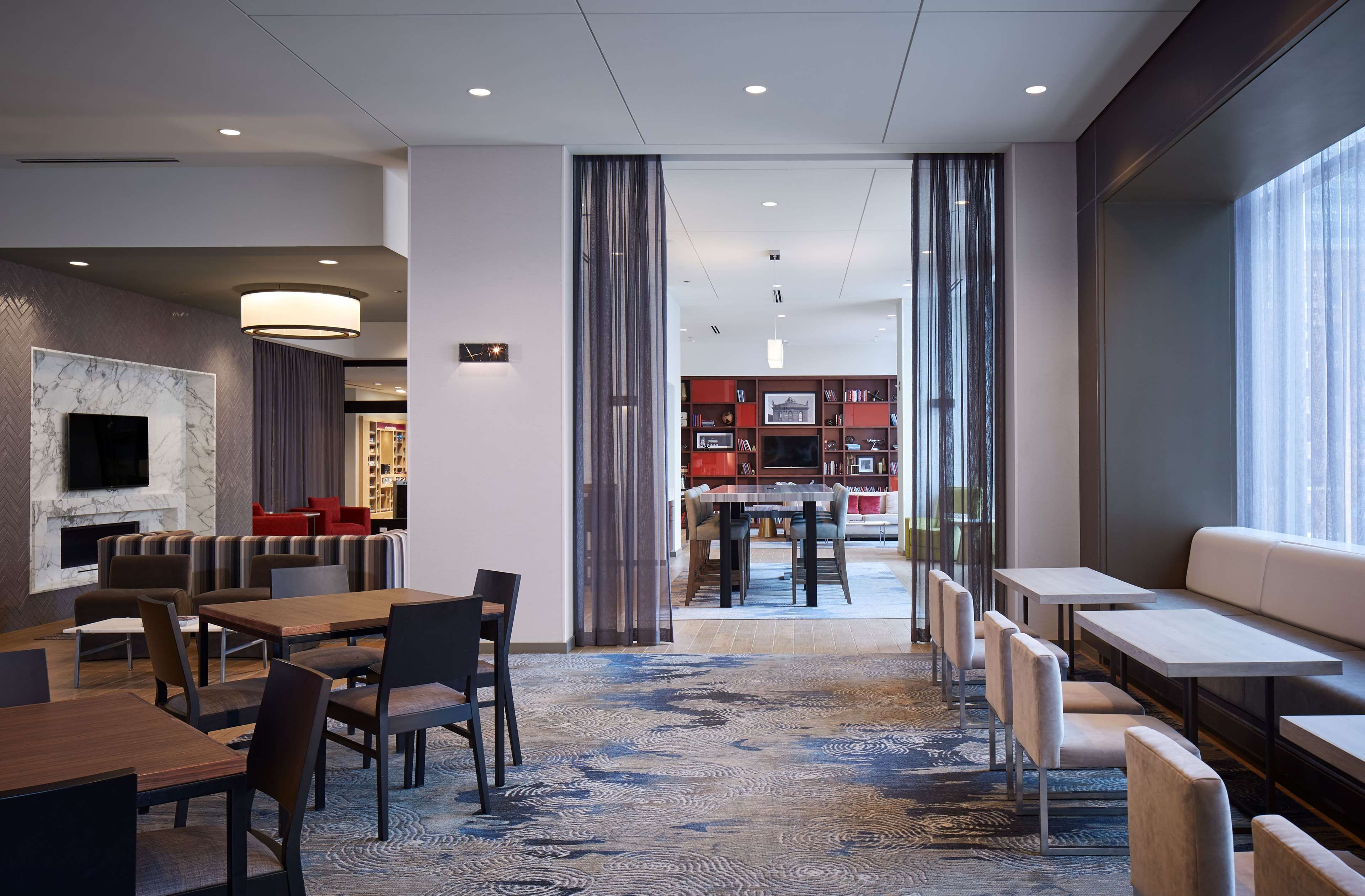 En hotellobby med en matplats, sittgrupper och utsikt över restaurangen.