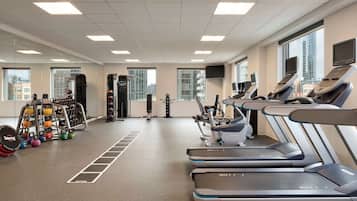 A gym with treadmills, weight machines, and kettlebells.