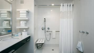 A modern bathroom with a shower, toilet, and sink.