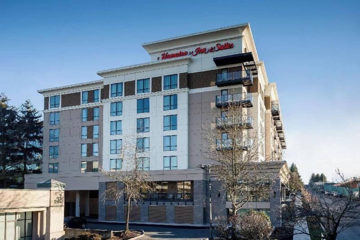A multi-story hotel with a prominent sign reading 'Hamilton Inn & Suites.'