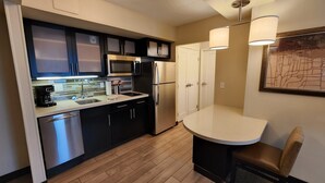A compact kitchen with modern appliances, a built-in microwave, and a coffee maker. - Staybridge Suites Denver Downtown by IHG (Denver)