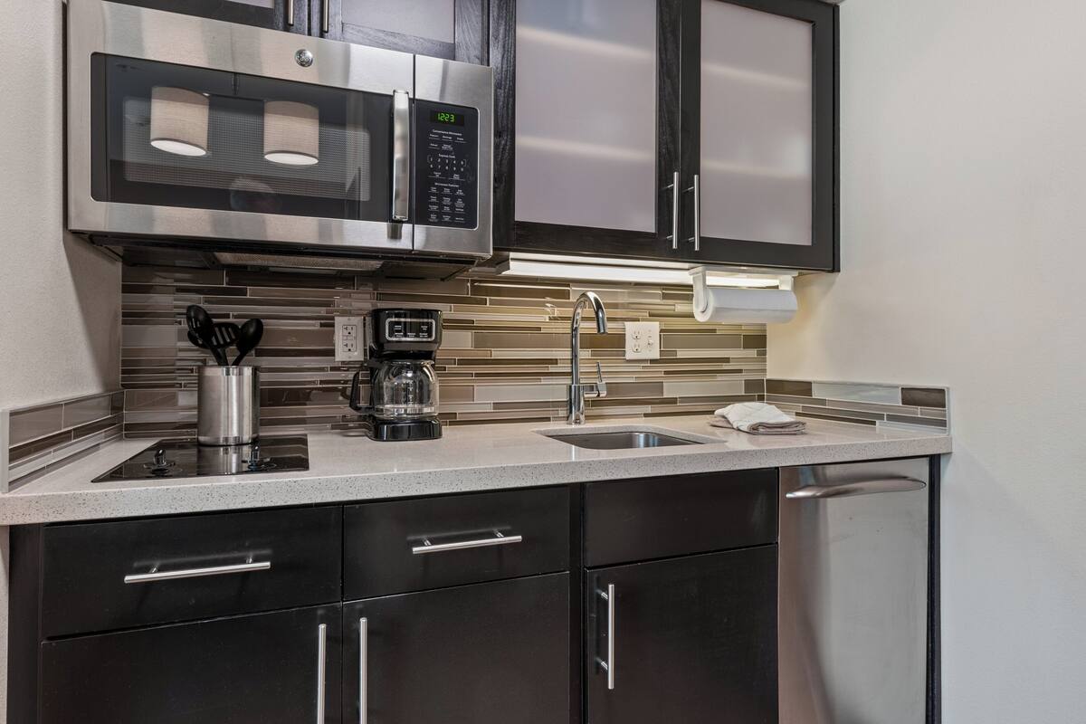 A modern kitchen with stainless steel appliances, a coffee maker, and a dishwasher.