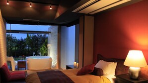 A modern bedroom with a large bed, a bedside table with a lamp, and a view of the outdoors. - Soratoniwa Atami Izusan (Atami)