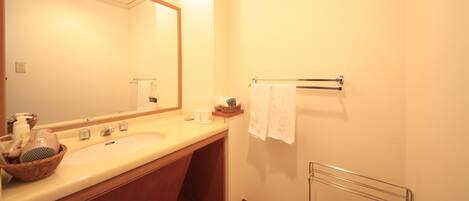 A bathroom with a large mirror, a sink, and a towel rack.