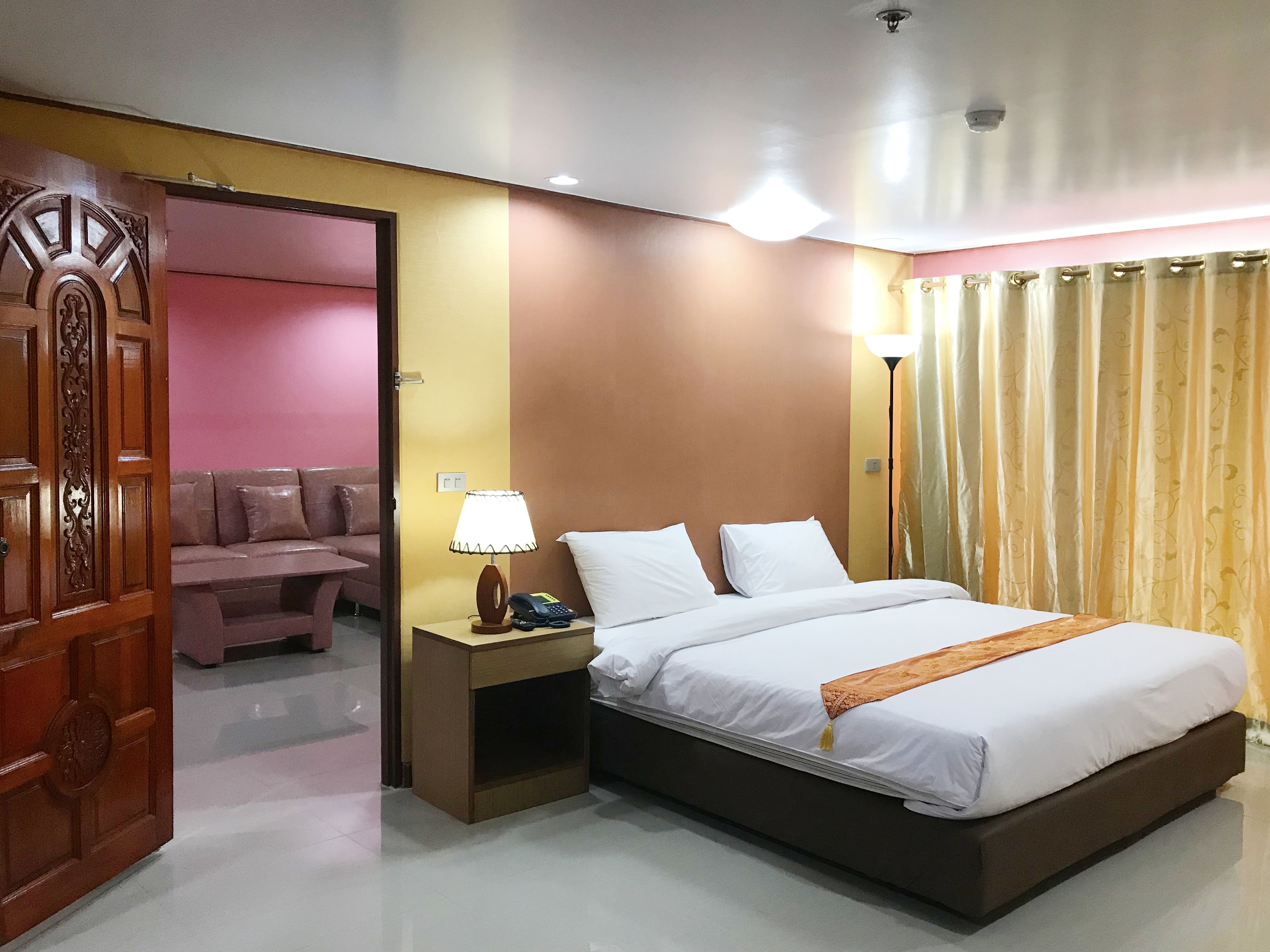 A hotel room with a bed, bedside lamp, and a nightstand.