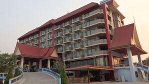 A multi-story hotel with a red roof and balconies. - Toh Buk Seng Riverside (Nakhon Luang)