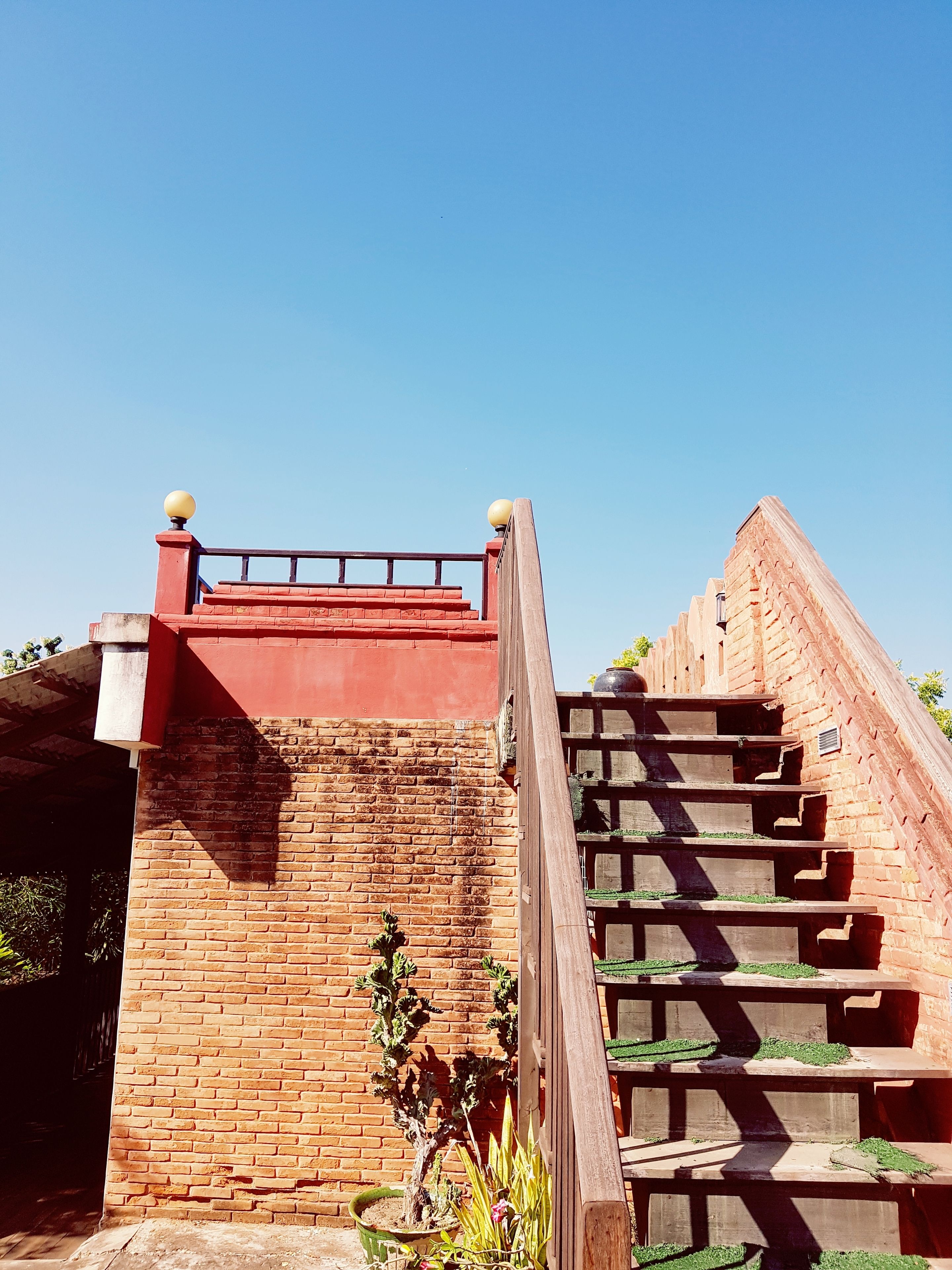 A staircase with a brick wall and a wooden railing.