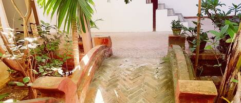 A herringbone-patterned stone staircase leading to a white wall.
