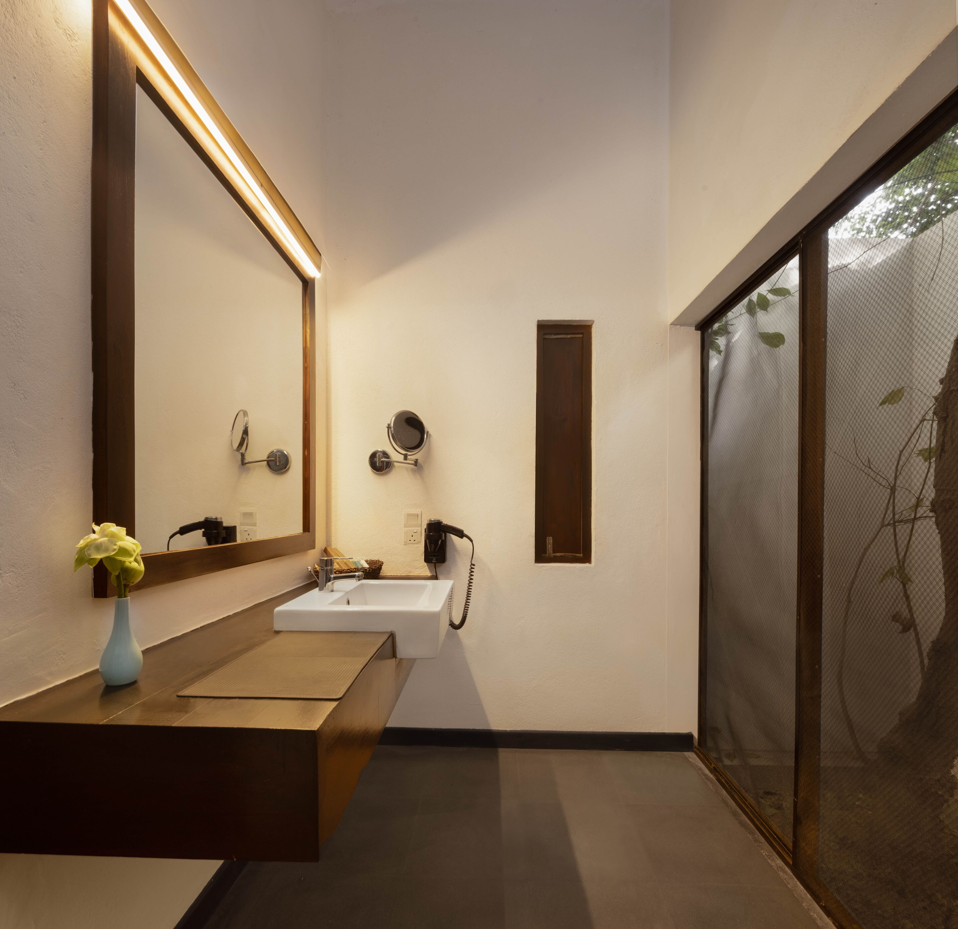 A modern bathroom with a large mirror, a sink, and a shower.