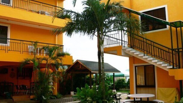 Un edificio de varios pisos con balcones, asientos exteriores y una escalera.