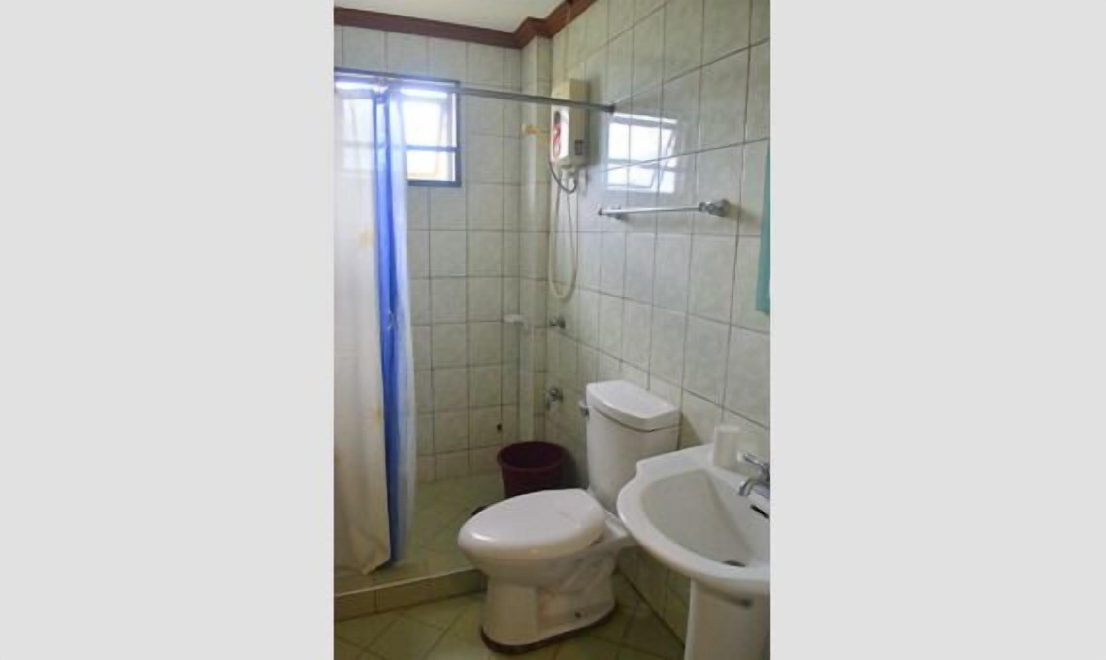 Un baño con ducha, inodoro y lavabo.