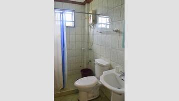 Un baño con ducha, inodoro y lavabo.