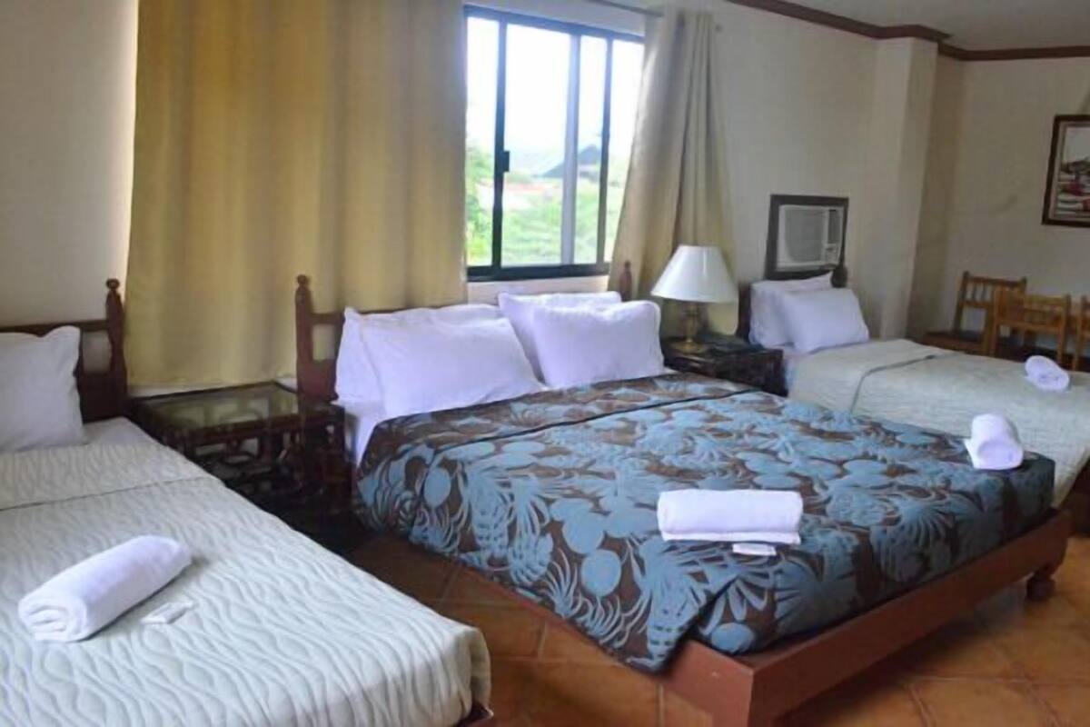 Una habitación de hotel con dos camas, una ventana, un escritorio y una silla.