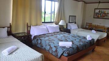Una habitación de hotel con dos camas, una ventana, un escritorio y una silla.
