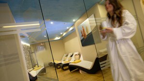 A modern spa room with a glass partition, wooden flooring, and a ceiling with recessed lighting. - Cimon Dolomites Hotel (Predazzo)
