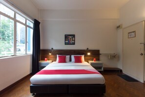 Una habitación de hotel con una cama grande, dos mesitas de noche, un armario, una ventana con cortinas, una puerta y un cuadro en la pared.
