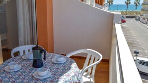 A balcony with a table set for two, a coffee pot, and two cups. - Apartamentos Voramar 3000 (Peniscola)