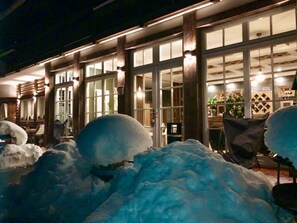 Un bâtiment doté de grandes fenêtres et dont l’entrée est recouverte de neige.