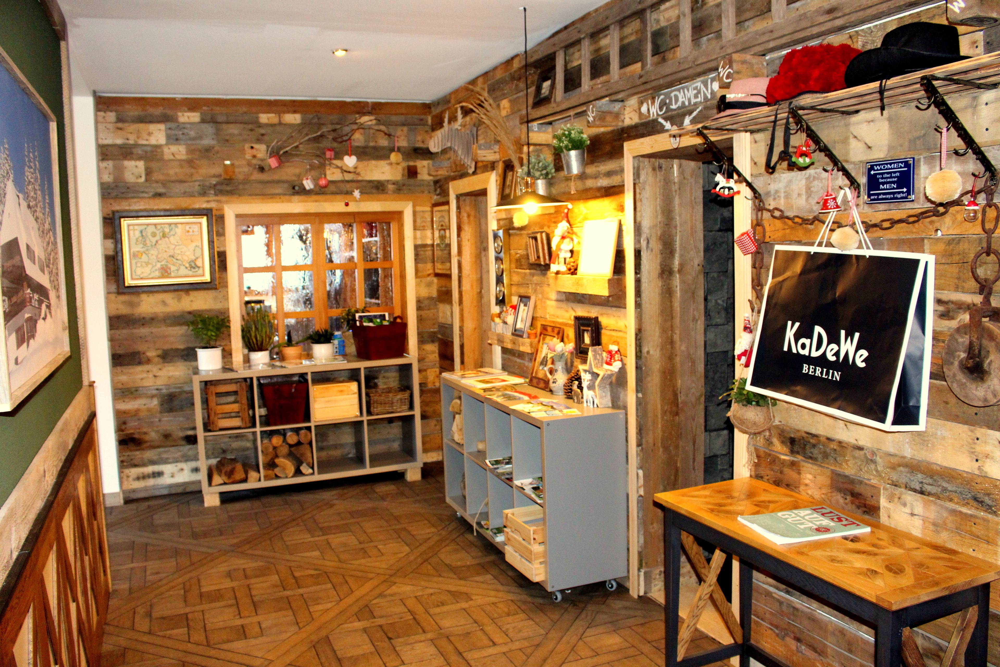 Een gezellig interieur met houten wanden, planken met diverse spullen, en een bord waarop 