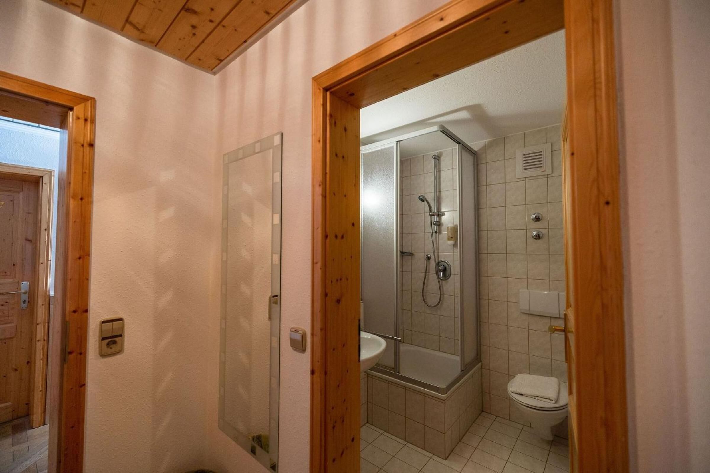 A bathroom with a shower, toilet, and sink.