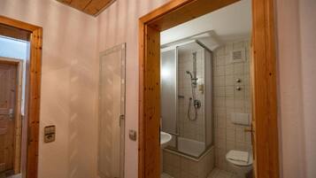 A bathroom with a shower, toilet, and sink.