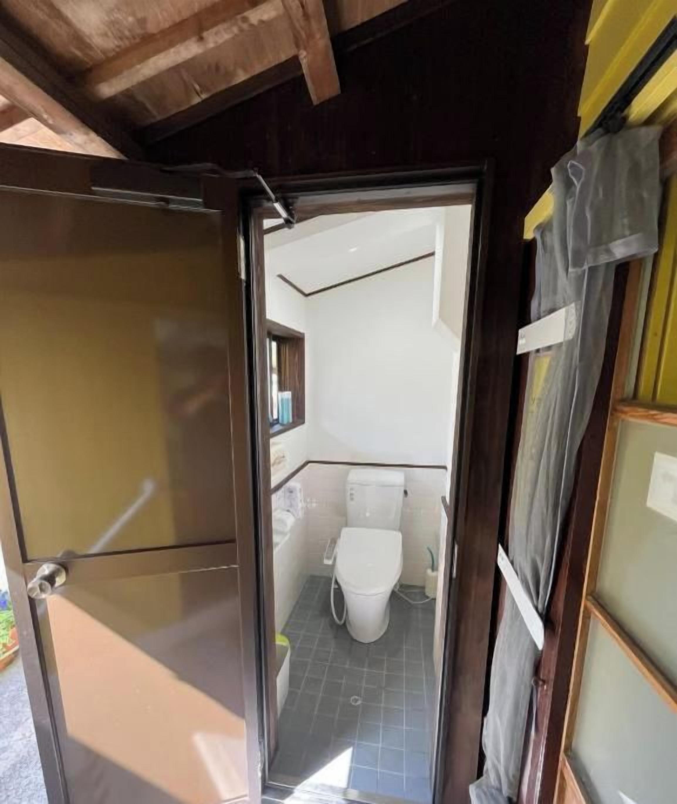 A porta dá acesso a um banheiro com vaso sanitário e pia.