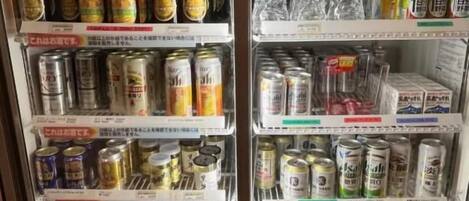 A beverage vending machine with multiple shelves stocked with cans and bottles.