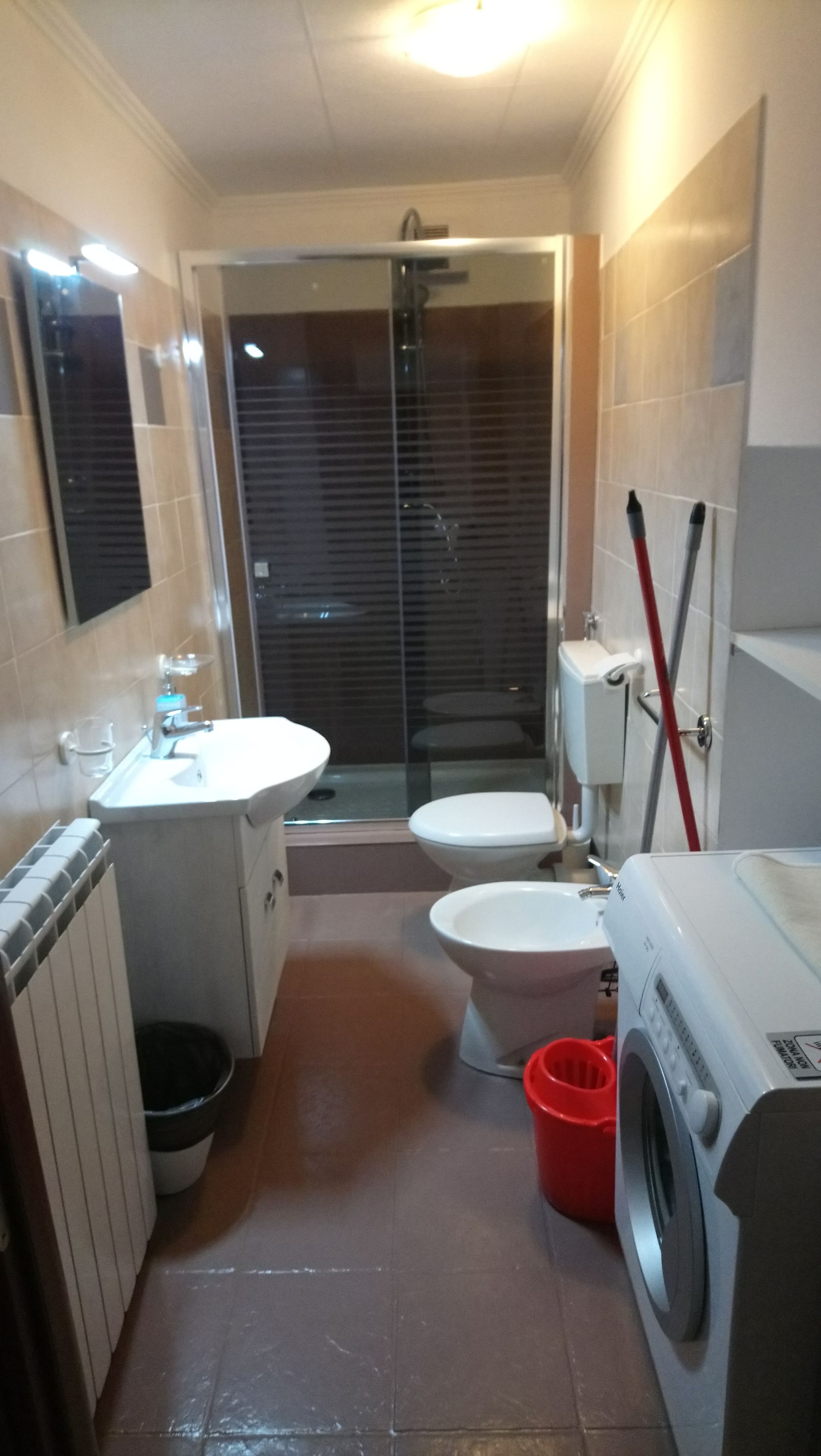 A compact bathroom with a toilet, sink, and shower.