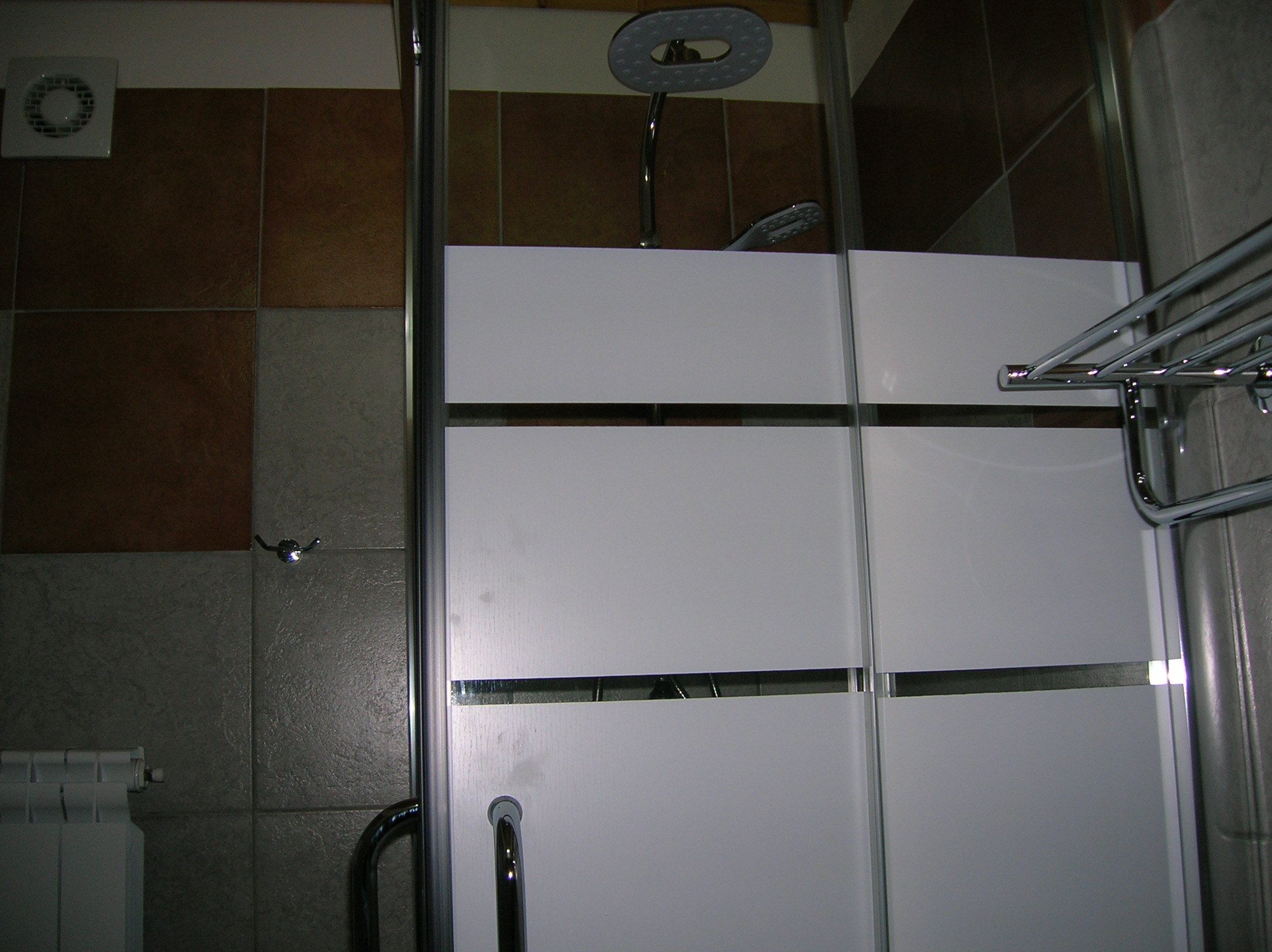 A bathroom with a shower, a toilet, and a sink.