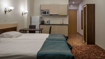 A hotel room with a bed, a desk, a microwave, and a wardrobe.