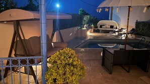 An outdoor pool area with lounge chairs, umbrellas, and a barbecue grill. - Hotel Kourkoumelata (Kefalonia)