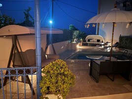 Una piscina al aire libre, sombrillas, sillones reclinables de piscina